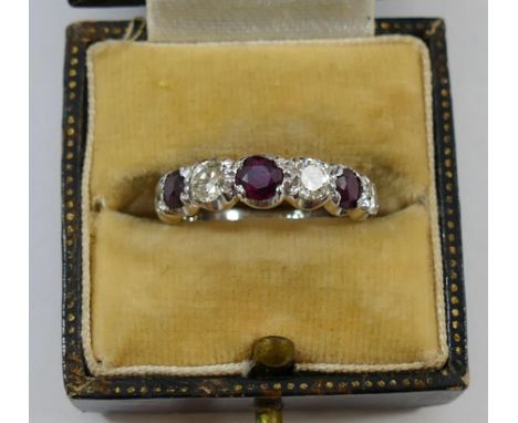 An 18 carat white gold ruby and diamond seven stone half eternity ring, London 1974, the five round brilliant cut diamonds ap