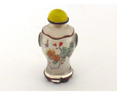 A Chinese baluster shaped glass snuff bottle, internally painted with flowers, the body cased in dark ruby glass cut back lea