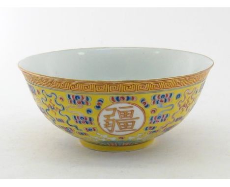 A Chinese ceramic famille rose yellow ground deep bowl on a circular foot rim, decorated with four Chinese characters in circ