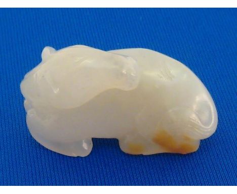 A Chinese white jade carving of a recumbent horse, in very white colour with tiny brown skin, 19th/20th century, 3.5cm long 