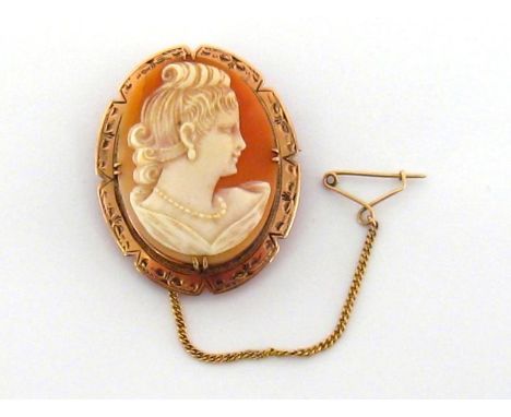 A late Victorian shell cameo brooch, the oval cameo depicting a woman in profile, 3.6cm long, in a gold surround, stamped '9c