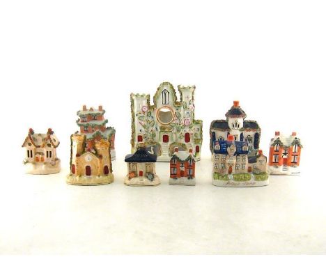 A collection of nine 19th. century and later Staffordshire flatback ceramic models, money boxes, pastille burners and a clock