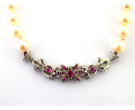 A single strand of rope length cultured pearls, composed of uniform 7.9mm pearls, to a ruby set clasp, the hook fitting stamp