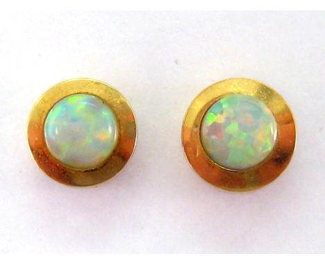 A pair of synthetic opal ear studs, the small rub over set stones 4mm diameter, stamped '14k', butterfly fittings, 1.8gms 