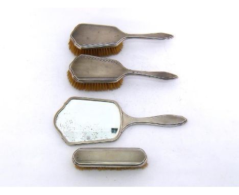 A four-piece silver-backed dressing table set, London, 1946/47, comprising hand-mirror, clothes brush and pair of hair-brushe