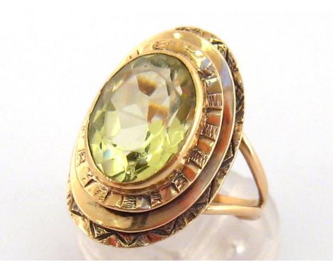 A 9 carat gold and citrine ring, the central oval cut stone 13.5 x 10mm, in a three tiered surround, the shank with London im