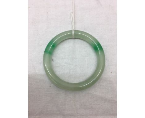 A Qing Dynasty jadeite bangle in apple greens and celadon: a wedding gift to a bride in Hong Kong from family, c1910