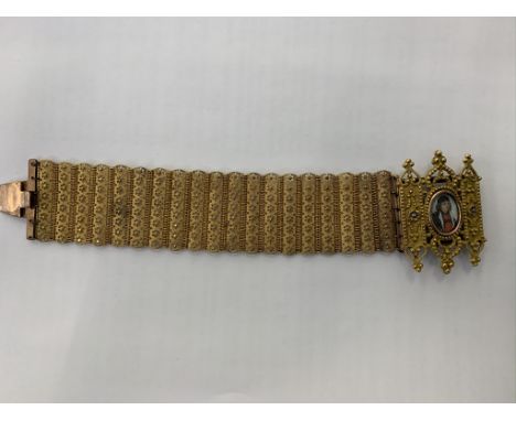A 19th century bracelet containing a painted portrait miniature of a Tudor gentleman surrounded by rose emblems