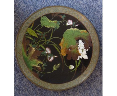 An early 20th century Japanese cloisonné Dish decorated in enamels with lilies etc. within a diaper-style border, 30cm diamet