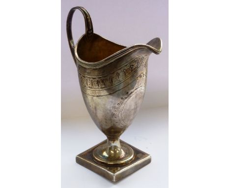 A neo Classical style helmet shaped silver Cream Jug, engraved bright cut decoration, high arched handle and raised on square