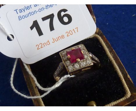 A ladies 9 carat yellow gold square Dress Ring, the central red cushion cut stone (possibly ruby) surrounded by white paste s