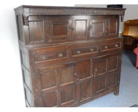 A large 18th Century oak Court Cupboard, the frieze initialled RT and BT and dated 1729 and flanked by incised decorative car