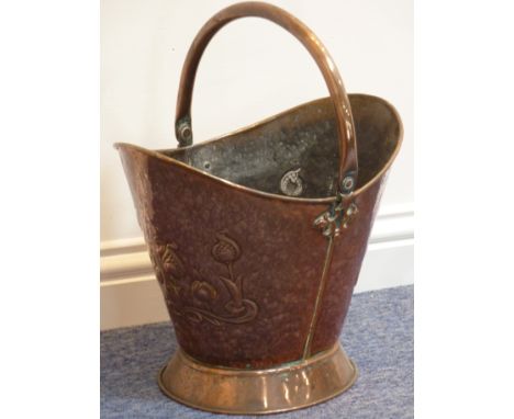 A late 19th/early 20th century copper Coal Bucket, the swing-handle above two ends with hammered stylised Art Nouveau decorat