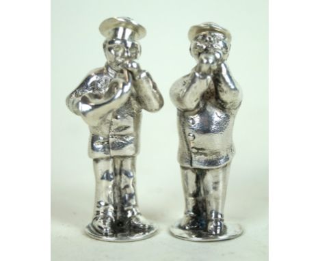 A Victorian silver pair of novelty pepperettes
Each depicting a gentleman playing a musical instrument, one playing a whistle