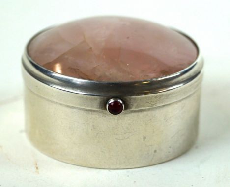 A George V silver and rose quartz trinket box
Of circular form, the lid set with a cabochon cut rose quartz, a red stone set 