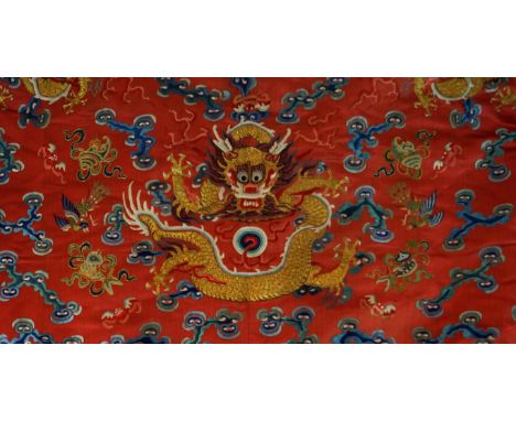A Chinese embroidered 'Dragon' robe, early 20th Century
The pink/red silk robe with light blue silk lining, the front with th