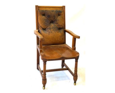 A Victorian light oak office armchair
The distressed buttoned leather back panel above dished seat, flanked by outswept open 