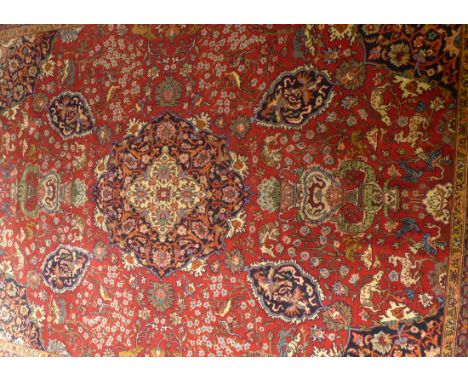 A large Persian style rug 20th Century
Mainly terracotta ground, the central panel with floral decorated central lozenge flan