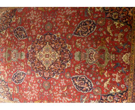 A large Persian style rug 20th Century
Mainly terracotta ground, the central panel with floral decorated central lozenge flan