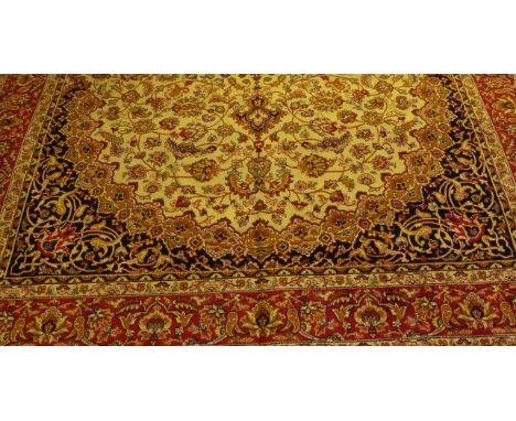 A Keshan carpet
On a mainly beige ground, the central panel with multiple floral decoration flanked by mulitple floral border