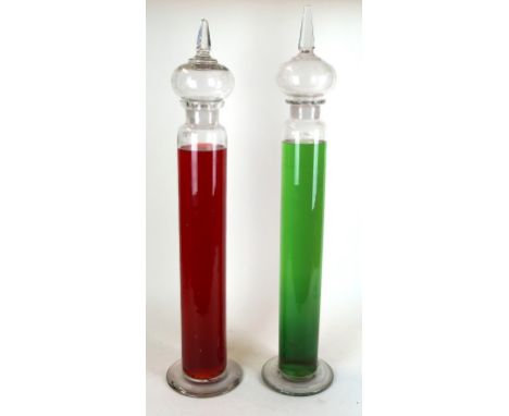 Two Victorian glass apothecary chemist liquid jars
Each of cylindrical form with bulbous stoppers with cut glass finials, ori