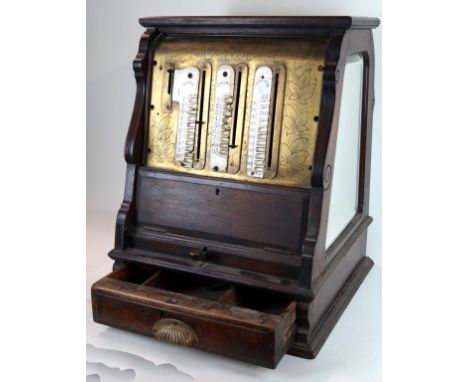 A rare International cash register 
Having stained beech wooden frame, with three bevelled mirror plates and three ceramic pl