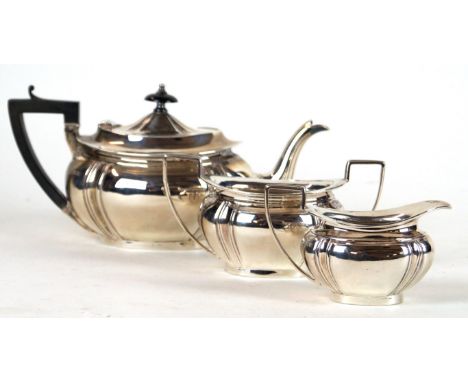 A silver three piece tea service
Of ovoid form, with embossed panelled decoration two angular handles, raised on an oval foot