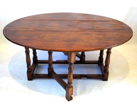 An 18th Century style oak drop leaf dining table and eight ladder back dining chairs, 20th Century
The table of oval form, ra