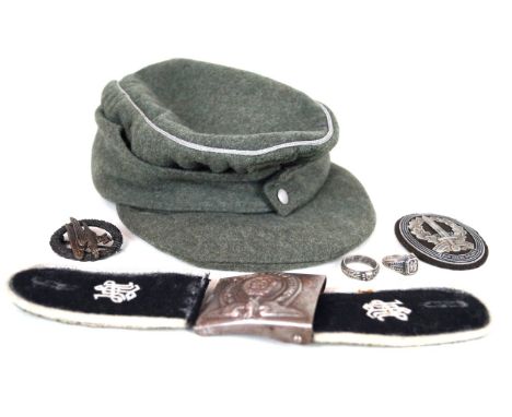 A Nazi Germany belt buckle
A green German army field cap dated 1944, two shoulder tabs, a Luftwaffe paratrooper's badge, a Ge