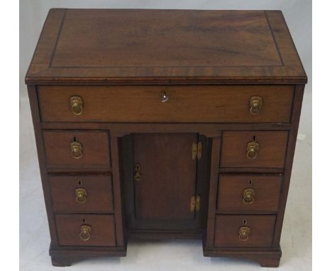 An 18th Century early George III mahogany kneehole desk
The cross banded rectangular top inlaid with ebony stringing above on