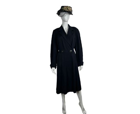 A navy blue 1940s coat with arrow seaming, full sleeves and princess seaming along with a 1940s raffia hat with net and pale 