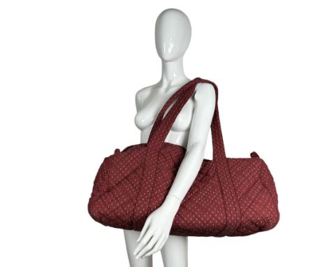 A quilted weekend bag by Laura Ashley, made in 1981 from “nutmeg” fabric. The bag has two top handles and fastens with a long