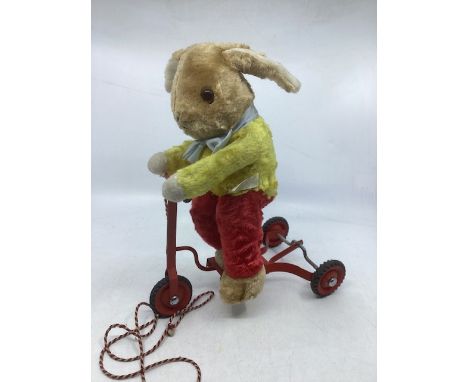 Vintage Chiltern Rabbit on a metal framed scooter, with pull along cord and the Rabbit scoots along mechanically as the wheel