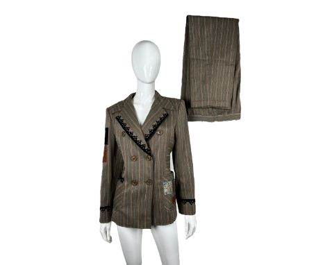 A 1990s suit by Christian Lacroix with tailored jacket and wide legged trousers with turn ups. Brown wool with pinstripes in 