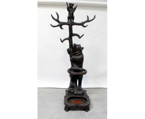 A reproduction Black Forest style oak carved hall stand in the form of a bear grasping a tree, looking up at its cub, the bas