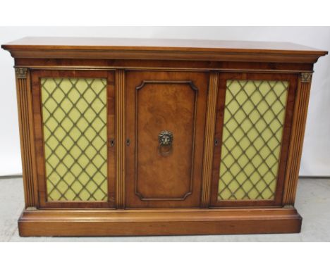 A reproduction French-style yew wood chiffonier comprising three cupboard doors, a centre door with lion head ring handle fla