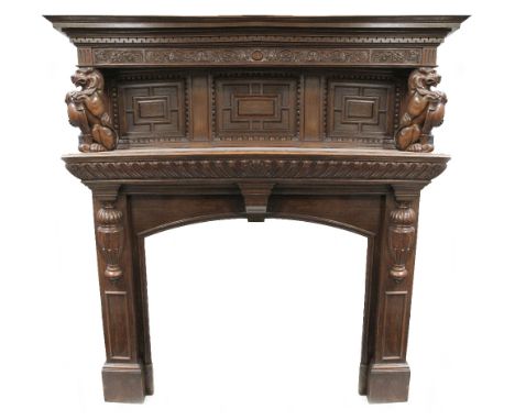 A late 19th/early 20th century large and impressive oak fire surround and mantel, the moulded cornice above carved panel depi