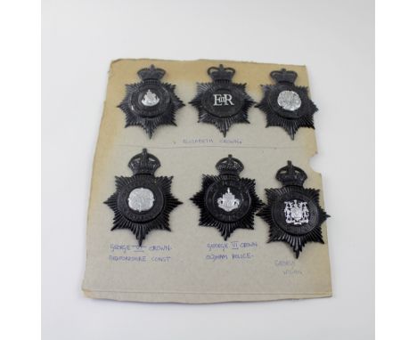 A board of six Police helmet badges, three pre-1953 and three post-1953.