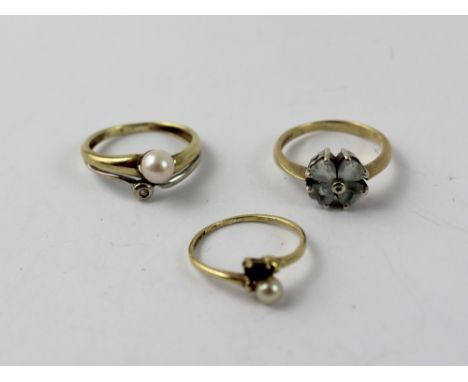 A 9ct gold dress ring set with four pale blue leaf shaped stones, size J, a 9ct gold ring set with a small diamond and pearl,