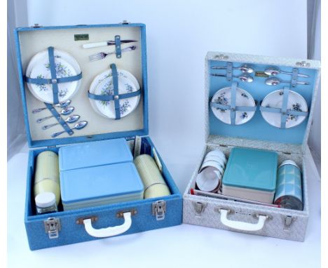 A Brexton picnic case with fitted interior containing four forget-me-not patterned plates, four saucers, four teaspoons, a kn