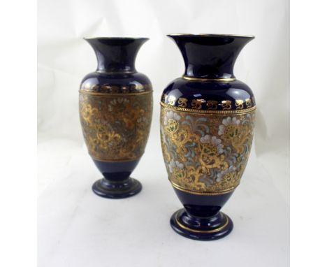 DOULTON LAMBETH; a pair of large blue vases with flared rims, with central panel of enamel flowers on gilt ground, maker's st