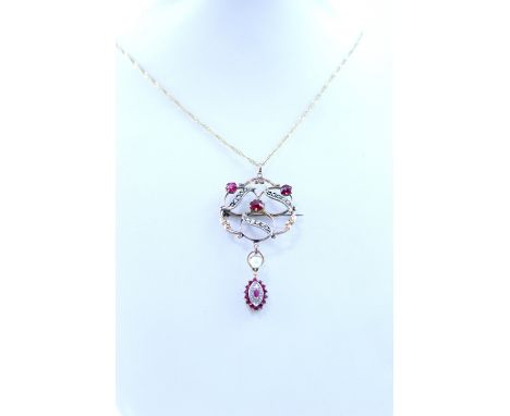 An Edwardian yellow metal openwork ruby and pearl pendant on 18ct yellow gold chain, marked 750, length of chain approx 60cm.