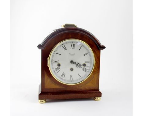 A Comitti of London oak mantel clock, the white dial set with Roman numerals, raised on brass-coloured bun feet, height 24cm,