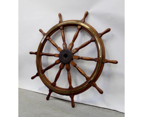 A large ship's wheel with inset brass ring and numbered to the central hub 493, diameter approx 170cm. CONDITION REPORT Diame
