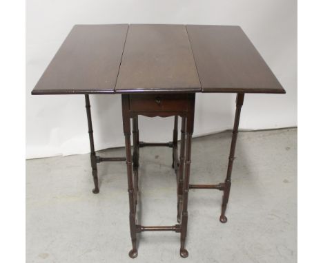 An 18th century style mahogany gateleg table on ring turned supports and pad feet, the drawer with ivorine retailer's label '