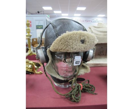 A Leather/Sheepskin RAF Pilot's Style Flying Helmet; plus a pair of WWII period 'BBC' headphones, all on a glass shop head (n