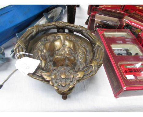 A large brass Lion head door knocker