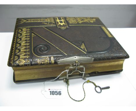 A Late XIX Century Leather Bound Photograph Album, with musical movement playing two airs, the pages with lithographic scenes