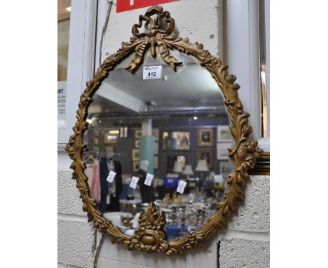 Gilt metal framed mirror with foliate design and ribbon mount. (B.P. 21 + VAT) Minor wear to mirror, needs a good clean. 50x4