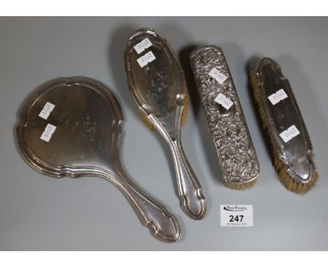 Bag of silver vanity items to include hand mirror and three brushes, one with floral and foliate engraved decoration.(B.P. 21